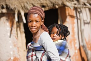 Une maman porte son bébé en écharpe en Afrique.